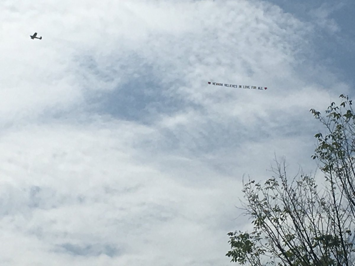 Air assault— Banner flying over site of neo-Nazi rally in downtown Newnan reads, Newnan believes in love for all. Counter demonstrators are cheering, chanting, waiting to see if the neo-Nazis show up. The group's permit for the rally was for 3:00-5:00 ET - 11Alive   