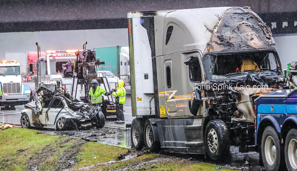 Vehicles are   moved off to the side by wreckers on I-285 west at Riverdale Road as only 2-lanes are open, backing traffic to I-675 