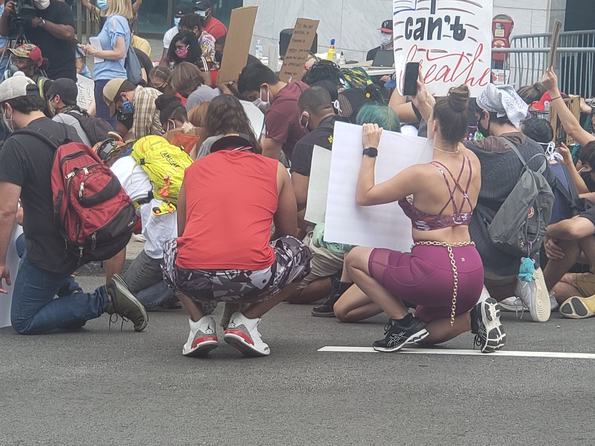 Protestors kneel for a moment of silence for all those who have died at the hands of police officers at Atlanta City Hall.