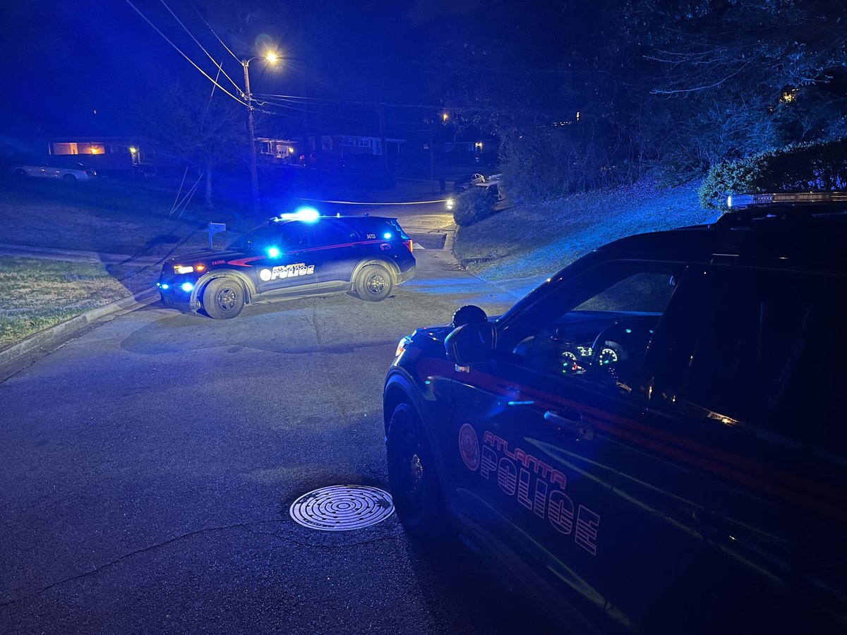 Atlanta Police on scene of homicide/shooting investigation on Baker Road in NW Atlanta.  shell casings in middle of street and police focusing on a small SUV parked on curb. 