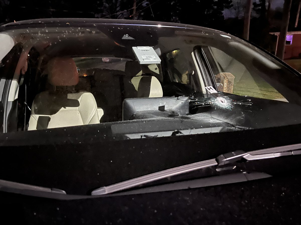 Can see bullet holes in window of home and through windshield of car on streetat scene of murder of a man on Baker Road in NW Atlanta. Victim is a 30 year old man who police say doesn't live here