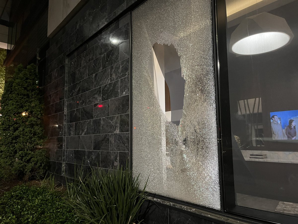 Window with bullet hole through it i Midtown after shooting death of man in front of luxury high rise on Juniper St